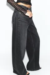 Jeans de tiro medio y corte wide leg en color marrón oscuro, con diseño de cinco bolsillos y cierre frontal con cremallera y botón metálico.