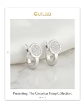 Caravanas de plata con diseño circular pavé, adornadas con pequeñas circonias brillantes y cierre catalán.