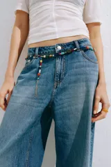 Jean de tiro alto y corte baggy, confeccionado en denim de algodón rígido en color celeste con efecto deslavado. Presenta diseño de cinco bolsillos, piernas rectas y holgadas, y cierre frontal con botón y cremallera.