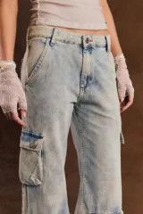 Pantalón cargo de denim celeste con efecto acid wash, corte ancho y múltiples bolsillos con solapa en los laterales y a la altura de las pantorrillas.