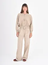 Campera tipo bomber de corte cropped, con cierre frontal, cuello redondo y puños elásticos, confeccionada en tela con efecto lavado.