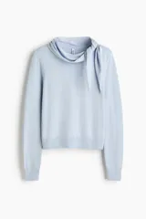 Buzo en punto fino de mezcla de viscosa color celeste, modelo entallado con cuello pañuelo integrado y remate acanalado en puños y bajo.
