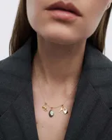 Collar dorado con dije de labradorita, un dije de oso de peluche y un dije de candado con llave.