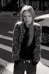 Chaqueta abierta de punto con cuello redondo y manga larga. Presenta un diseño de jacquard con estampado animal y detalles de ribetes en color negro en cuello, puños y borde frontal.
