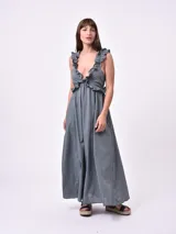 Vestido largo color gris con breteles finos y volados en el escote. Corte imperio y falda amplia.