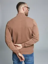 Remera tejida gris con cuello alto y medio cierre.