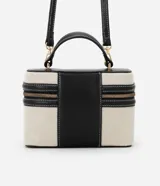 Cartera pequeña tipo bandolera de la marca Satinato, color beige con detalles en negro, confeccionada en una mezcla de algodón y poliuretano con forro de poliéster. Cuenta con tapa con doble cierre, cordón decorativo, asa de mano y correa larga removible.