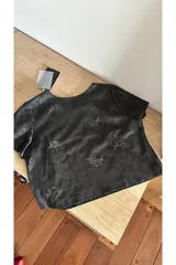 T-shirt negra de cuero con patrón floral diseñado con láser de alta calidad.