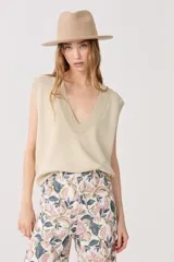 Chaleco tejido color dorado con lurex, escote en V y terminaciones de rib.