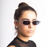 Lentes de sol con armazón ovalado de estilo retro en color negro y cristales oscuros. Presentan un detalle metálico en forma de estrella en las patillas.