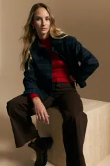 Tapado corto de lana con diseño a cuadros en tonos azul y negro, cuello camisero y cierre frontal con botones.