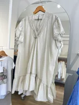 Vestido blanco de corte suelto, con escote en V y mangas cortas con detalles bordados.