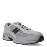 Championes urbanos New Balance modelo 509, color gris, confeccionados en una combinación de malla y gamuza. Presentan el logo 'N' en color negro en los laterales y suela con tecnología ABZORB para mayor amortiguación.