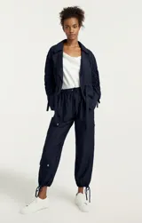 Pantalón parachute azul marino de tiro alto con bolsillos cargo y cordones ajustables en los tobillos.