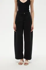 Pantalon de jean estilo barrel, color natural, de tiro medio con bolsillos laterales y cierre frontal.