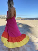 Vestido largo de tirantes color fucsia con volados en el ruedo en amarillo y naranja.