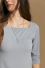 Remera de tejido acanalado (rib) color blanco, con escote cuadrado y mangas tres cuartos, de ajuste entallado al cuerpo.