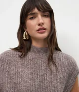 Chaleco de punto gris oscuro con textura jaspeada, diseño sin mangas, corte holgado y cuello alto tipo mock neck.