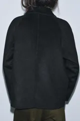 Chaqueta de corte recto confeccionada en mezcla de lana, color negro. Presenta cuello solapa, manga larga y cierre frontal con botones a tono.
