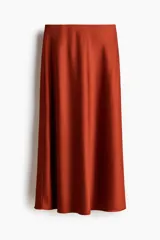Pollera midi de tejido satinado color terracota, con corte fluido, elástico oculto en la cintura y leve vuelo en el bajo.