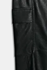 Pantalón cargo de tiro alto confeccionado en material efecto piel. Presenta bolsillos laterales con solapa, bolsillos delanteros y traseros, con cierre frontal de cremallera y gancho metálico.