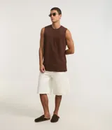 Musculosa básica de hombre, color blanco, con cuello redondo, sin mangas y pequeña etiqueta aplicada en el bajo.