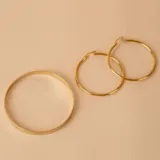 Aros tipo argolla de oro 18k con diseño torneado y acabado brillante.