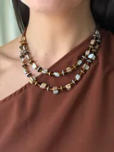 Collar doble de abalorios con cuentas de nácar teñido, discos de hematite dorados y plateados, y mostacillas tostadas, con cadena ajustable de acero quirúrgico.