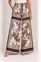 Pantalón palazzo de pierna ancha con estampado estilo toile de Jouy en tonos marrones y beige, cintura elástica con cordón ajustable.