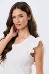 Remera de algodón color beige, de manga corta con volados de broderie, escote redondo y cuerpo liso.