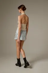 Falda mini de jean con diseño recto, bolsillos tradicionales y aplicación de strass brillante en el lateral.