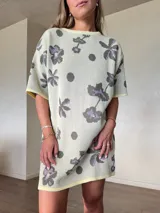 Vestido corto de tejido de punto de algodón con lurex, corte holgado, mangas cortas y cuello redondo, con diseño estampado floral y de lunares en tonos gris y lila sobre base beige claro.