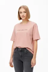Remera de manga corta color rosado, con cuello redondo a la base y estampado tipográfico frontal con la frase 'LUCKY GIRL AURA'.