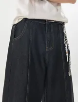 Jeans baggy de denim color azul oscuro, de corte ancho y relajado, con cintura semi-elástica en la parte trasera. Presenta bolsillos traseros con costuras a contratono y bordado de estrella en uno de ellos.