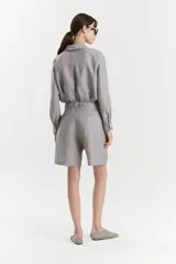 Bermuda de lino color gris con calce recto y diseño sastrero. Cuenta con cintura con pinzas, bolsillos frontales de estilo americano y cierre con botones ocultos.