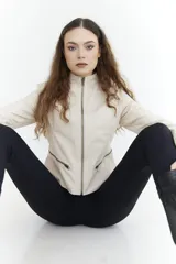 Campera corta de cuero sintético color beige, con cuello alto, cierre frontal y bolsillos laterales con cierre.