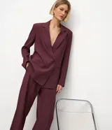 Blazer femenino color bordó, de corte oversized y caída recta. Presenta cierre traspasado con dos botones delanteros, mangas largas, cuello con solapa tradicional y bolsillos delanteros con acabado incorporado. Cuenta con forro interno.
