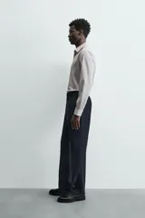 Camisa de manga larga para hombre, color gris claro con micro-estampado de cuadros sutiles. Presenta cuello italiano y cierre frontal de botonadura.