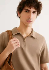 Chomba de manga corta en color beige, con cuello camisero y cierre frontal parcial.