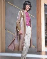 Tapado largo de lana merino afieltrada, color fucsia con diseño tie-dye artesanal en tonos claros y crudos. Tiene cuello que se prolonga a modo de cinto, aberturas laterales y bolsillos.