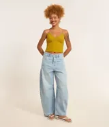 Pantalón de jean celeste, modelo barrel, con trabillas en la cintura, bolsillos y detalle de recorte en la entrepierna.