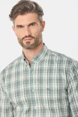 Camisa de manga larga con estampado de cuadros en tonos azules, grises y marrones. Presenta cuello abotonado, bolsillo frontal en el pecho y botones personalizados.