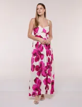 Vestido maxi de fondo blanco con estampado de flores grandes en tonos verde y marrón, con escote en V, breteles finos y detalle de abertura cut-out en el centro del busto.