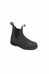 Botas Blundstone modelo 1910, de gamuza gris, con elásticos laterales negros, suela de goma negra y tiradores de tela con logo en la parte trasera.