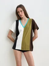 Remera de manga corta con diseño de bloques de color verticales en tonos negro, blanco, verde militar y marrón, con escote en V ribeteado en celeste.