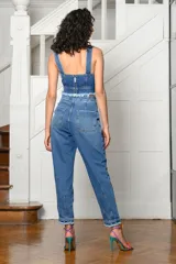 Pantalón de jean celeste con roturas, tiro alto, corte holgado y tobillos ajustados.
