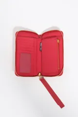 Billetera mediana de estructura rígida en color marrón topo, con cierre perimetral de cremallera y tirador decorativo de cordón. Presenta el logo de la marca aplicado en letras metálicas doradas en el frente.