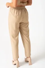 Pantalón palazzo color beige con finas rayas verticales blancas, tiro alto y cintura elastizada.
