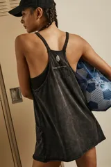 Vestido corto de tirantes finos, color negro con efecto acid wash, escote redondo y espalda cruzada. Cuenta con bolsillos de parche grandes en la parte delantera y un forro interior con costuras para shorts.