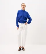 Campera de punto pesado color azul, con cuello alto, cierre frontal con cremallera y bolsillos delanteros con solapa y botones. Cuenta con mangas largas y puños y bajo acanalados.